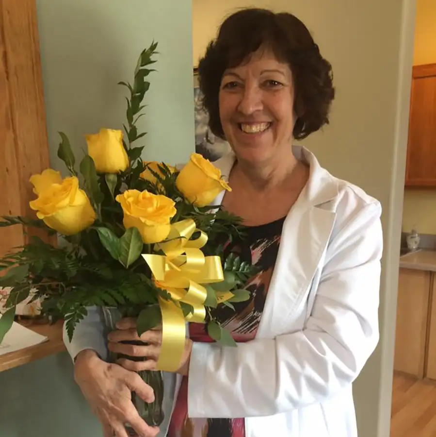 MSU Medical Services Unlimited - Dr. Penny Attaway DNP posing in office clinic with yellow roses - Vandalia, IL